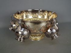 A silver plated punch bowl and six cups, gadrooned foot and lion mask handles,