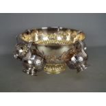 A silver plated punch bowl and six cups, gadrooned foot and lion mask handles,