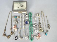 A small metal box and contents of assorted costume jewellery,