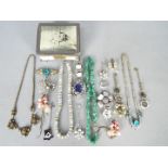 A small metal box and contents of assorted costume jewellery,