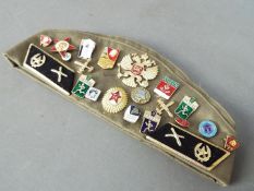 A collection of Soviet Russian badges displayed on a Russian military beret together with three