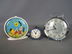 A Smiths 'Sooty and Sweep' alarm clock and two further alarm clocks.