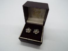 9 ct Gold - a pair of 9 ct gold earrings with a floral design, both with butterfly backs,