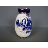 A Doulton Burslem vase of lobed form with blue floral and gilt decoration against a white ground, c.