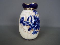 A Doulton Burslem vase of lobed form with blue floral and gilt decoration against a white ground, c.