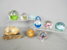 Seven paperweights to include Millrace, Caithness and similar, stone eggs and other.