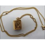 A 9ct gold chain with yellow metal (presumed 14ct gold) Koran / Quran pendant containing miniature