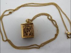 A 9ct gold chain with yellow metal (presumed 14ct gold) Koran / Quran pendant containing miniature