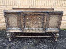 A large highly carved sideboard having three central drawers flanked by a cupboard each side,