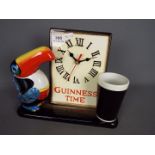 Breweriana - A ceramic Guinness advertising clock with toucan and pint glass,
