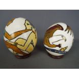 Two hand painted ostrich eggs with circular wooden stands.