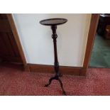 A mahogany torchere, the turned column raised on tripod supports,
