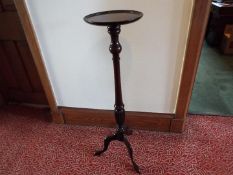 A mahogany torchere, the turned column raised on tripod supports,