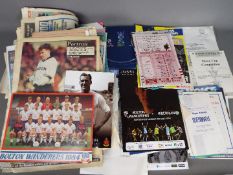 A collection of matchday programmes, newspaper pullouts,