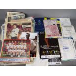 A collection of matchday programmes, newspaper pullouts,