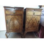 A pair of walnut veneered bedside cabinets each raised on four supports, with protective glass tops,