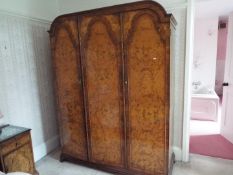A walnut veneered triple door wardrobe, originally purchased from Harrods,