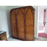 A walnut veneered triple door wardrobe, originally purchased from Harrods,