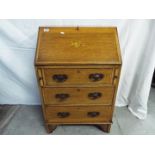 A writing bureau with fall front and fitted interior over three drawers,
