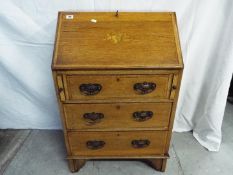 A writing bureau with fall front and fitted interior over three drawers,