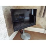 A Bang & Olufsen Beovision Horizon 40" flatscreen television on stand, with remote and instructions.