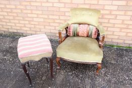 An upholstered armchair with mahogany frame, the supports terminating in casters,