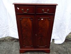 A mahogany cabinet having twin doors with two drawers above,