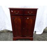 A mahogany cabinet having twin doors with two drawers above,