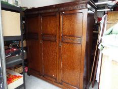 A large triple door wardrobe with carved detailing,