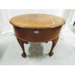 An oval top sewing box (and contents) raised on four ball and claw supports,