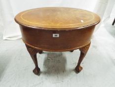 An oval top sewing box (and contents) raised on four ball and claw supports,