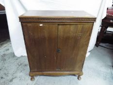 A vintage twin door cabinet raised on four supports, approximately 88 cm x 73 cm x 38 cm.