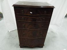 A serpentine front, mahogany chest of drawers, approximately 91 cm x 53 cm x 37 cm.