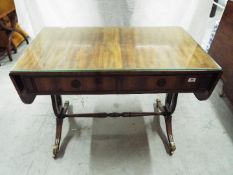 A good quality side table with drop leaf ends, twin drawers and protective glass top,