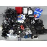 A collection of cameras, vintage mobile phones and chargers.