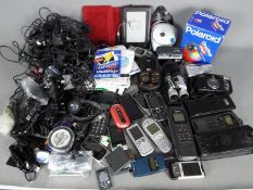 A collection of cameras, vintage mobile phones and chargers.