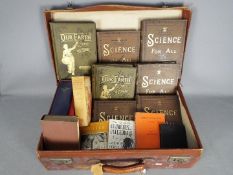 A vintage suitcase containing a quantity of hardback books on art, science, history and similar.