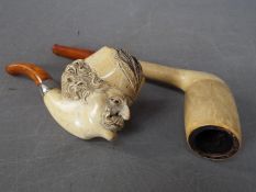 A meerschaum pipe, the bowl carved in the form of a gentleman's head and one other.