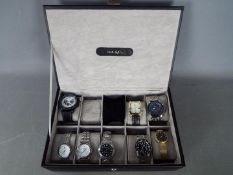 A Mele & Co watch box for storing 10 watches, containing eight fashion watches.