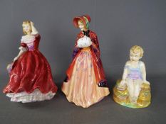 Three Paragon figurines, two depicting a lady and one of a child sitting on a rock.