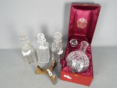 Four decanters, two with ceramic bottle labels (whisky and gin),
