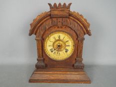 An Ansonia mantel clock having arched case with carved detailing, comes with key and pendulum,