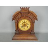 An Ansonia mantel clock having arched case with carved detailing, comes with key and pendulum,
