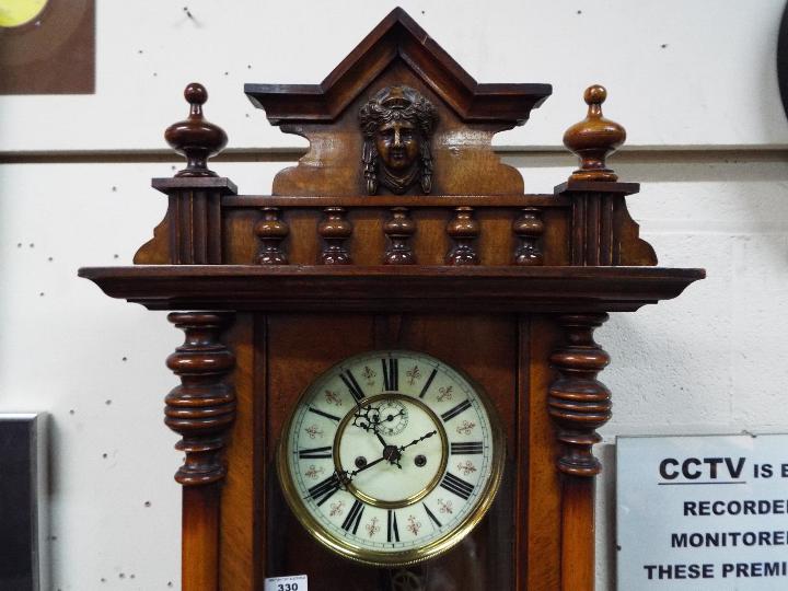 A highly carved walnut double weight Vienna wall clock with ceramic dial and pendulum - Image 2 of 6