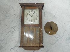 An oak cased wall clock with key and pendulum and brass sundial.