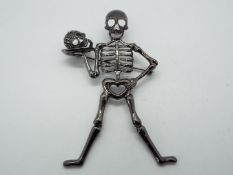 Butler & Wilson - a large Butler & Wilson stone set brooch in the form of a skeleton holding a