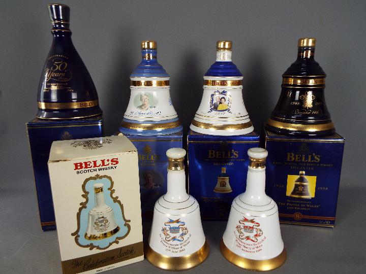 Six commemorative Bells ceramic whisky decanters (with contents) comprising four 70cl and two 50cl,