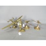 Four brass desk ornaments comprising a Lancaster Bomber, two Spitfires and similar.