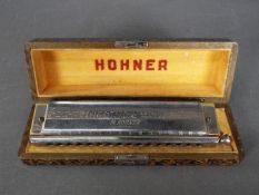 A cased Hohner 64 Chromonica Professional Model.