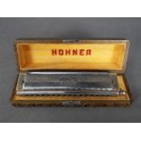 A cased Hohner 64 Chromonica Professional Model.